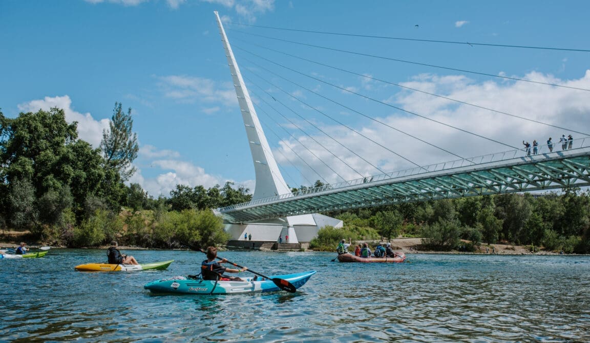 Kayakers paddling under the Sundial Bridge on the Sacramento River during the Sundial Splash