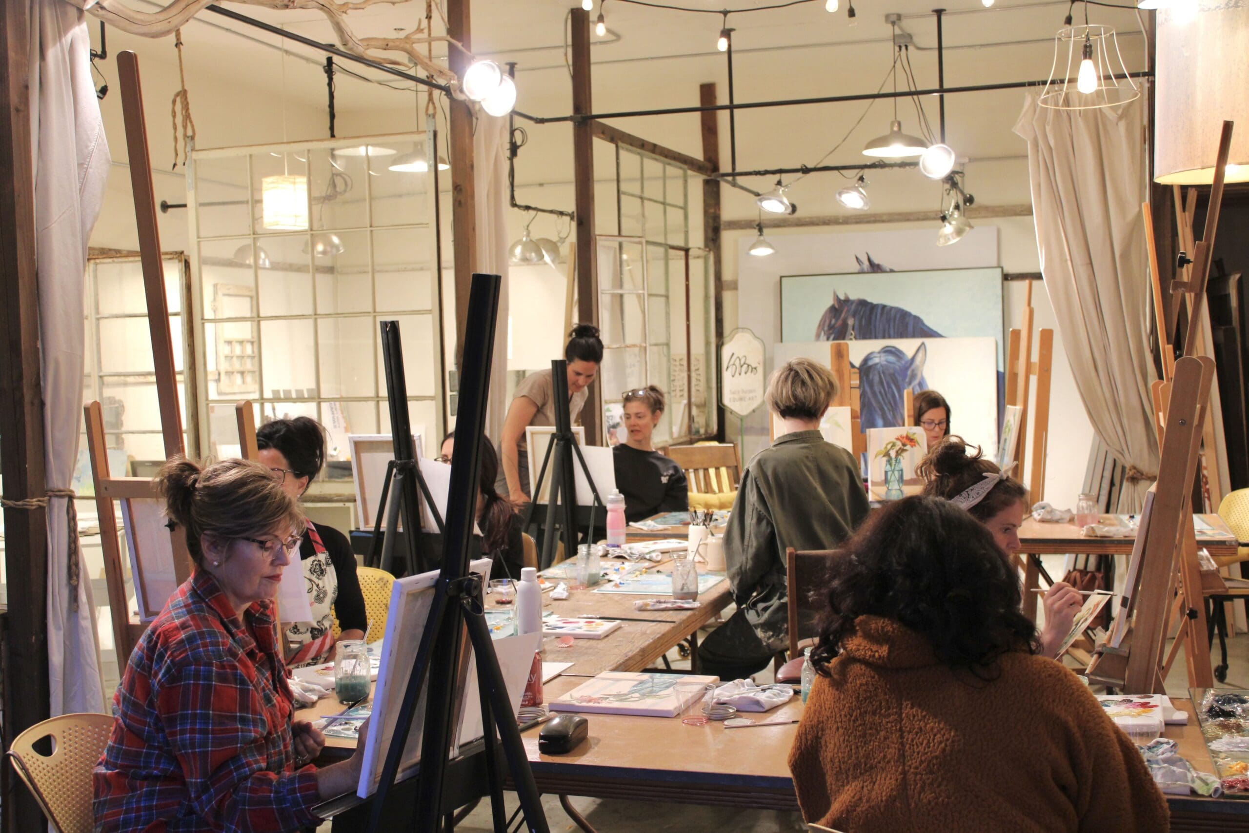 A photo of oil painting students at The Studio painting on easels.