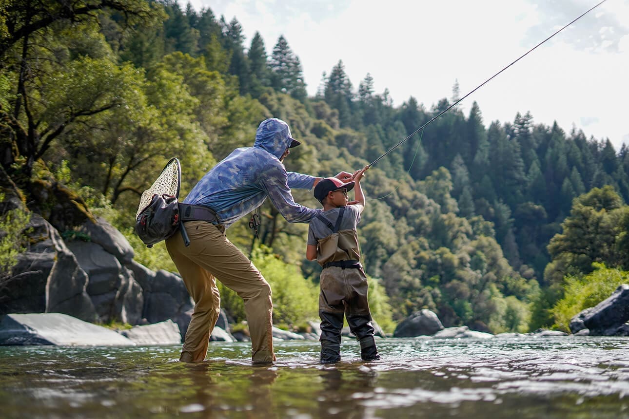 A kid and his guide fishing together in a stream near Redding, CA
