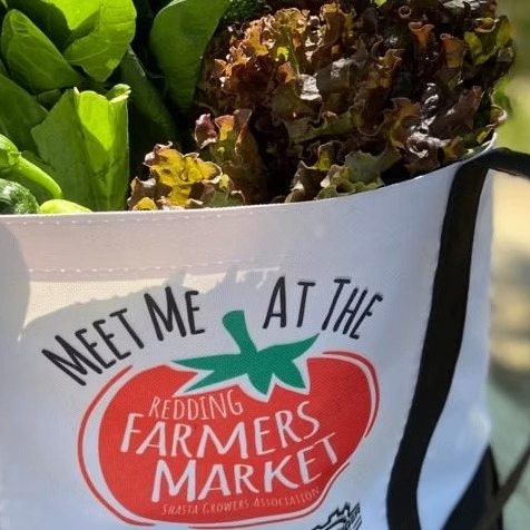 Bag of vegatables with the  Redding Certified Farmers Markets logo on it.